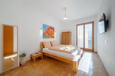 a bedroom with a large bed and a wooden floor at BozenApartments Garibaldi in Bolzano