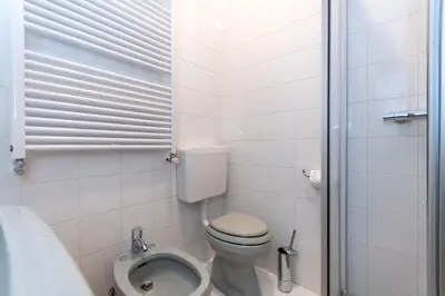 a small bathroom with a toilet and a shower at Ciasa al Sol in Falcade