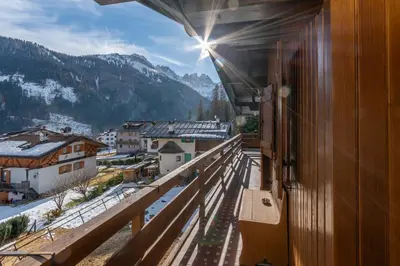 a balcony with a view of a town and mountains at Ciasa al Sol in Falcade