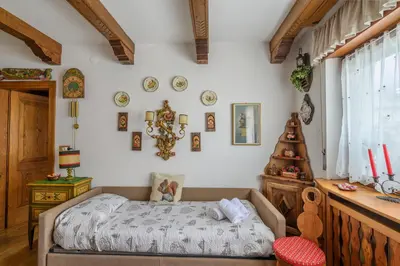 a bedroom with a bed and a table at Ca' dello Scoiattolo in Cortina dʼAmpezzo