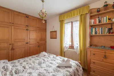 a bedroom with a bed with towels on it at Ca' dello Scoiattolo in Cortina dʼAmpezzo
