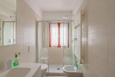 a white bathroom with a shower and a sink at Ca' dello Scoiattolo in Cortina dʼAmpezzo