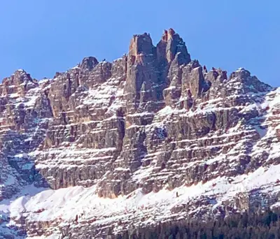 a large rocky mountain with snow on it at Ca' dello Scoiattolo in Cortina dʼAmpezzo