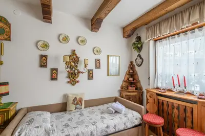a bedroom with a bed and a table and chairs at Ca' dello Scoiattolo in Cortina dʼAmpezzo
