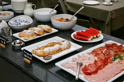 a table with different types of food on plates at Pension Pichler in Tirolo
