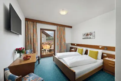 a hotel room with a bed and a television at Pension Pichler in Tirolo