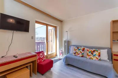 a room with two bunk beds and a red couch at Principe Marmolada 154 in Rocca Pietore