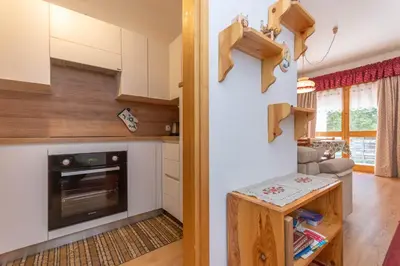 a kitchen with white cabinets and a stove at Appartamento Cordevole in Rocca Pietore