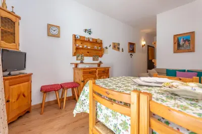 a dining room with a table and a tv at Appartamento Cordevole in Rocca Pietore