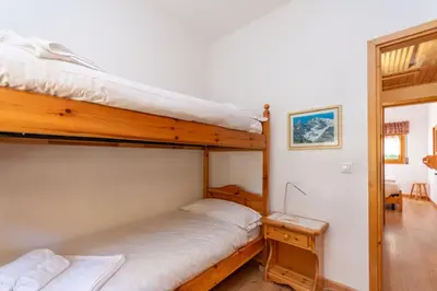 a bedroom with two bunk beds and a desk at Appartamento Cordevole in Rocca Pietore