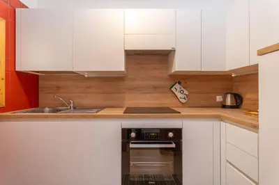 a kitchen with white cabinets and a dishwasher at Appartamento Cordevole in Rocca Pietore