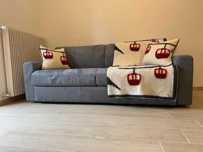 a blue couch with pillows on it in a living room at Ciasa Saslonch Apartment in Moena