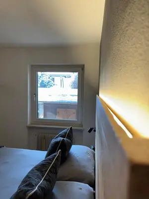 a bedroom with a bed with pillows and a window at Ciasa Saslonch Apartment in Moena