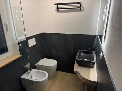 a small bathroom with a toilet and a sink at Ciasa Saslonch Apartment in Moena