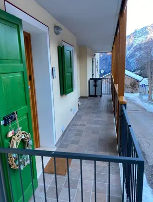 a house with green doors and a balcony at Appartamento Miramonti in Mas