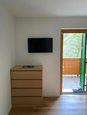 a room with a dresser with a television on a wall at Appartamento Miramonti in Mas