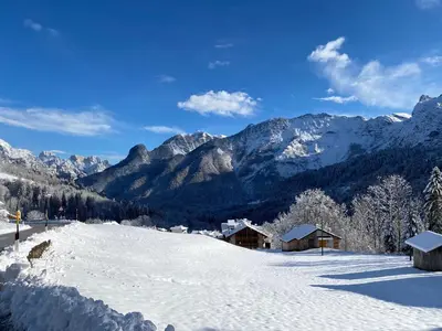 a snow covered slope with mountains in the background at Appartamento Miramonti in Mas