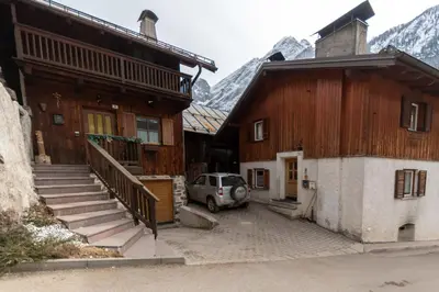 a car parked in front of a building with mountains at Appartamento Iori in Canazei