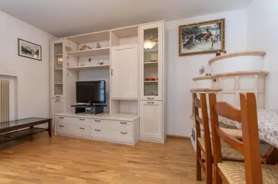 a living room with a tv and white cabinets at Appartamento Iori in Canazei