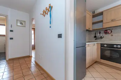 a kitchen with a refrigerator and a stove at Appartamento Iori in Canazei