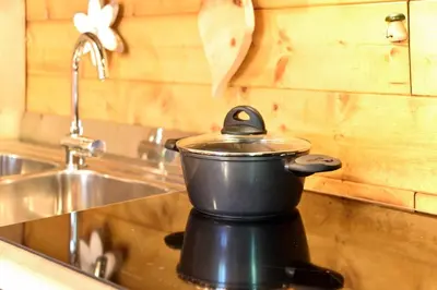 a pot sitting on top of a kitchen sink at Fienile Rustico Alleghe Tabià in Alleghe