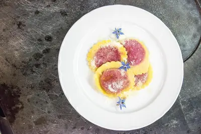 a white plate with a dessert on a table at Hotel Condor in San Vigilio Di Marebbe