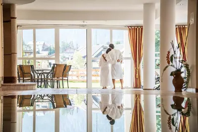 a couple standing in front of a window at Hotel Condor in San Vigilio Di Marebbe