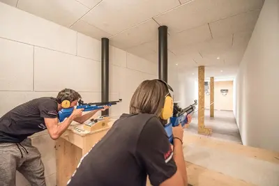 two people playing with toy guns in a room at Hotel Condor in San Vigilio Di Marebbe