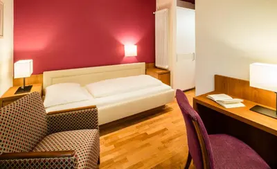 a room with a bed and a desk and a chair at Villa Bavaria in Merano