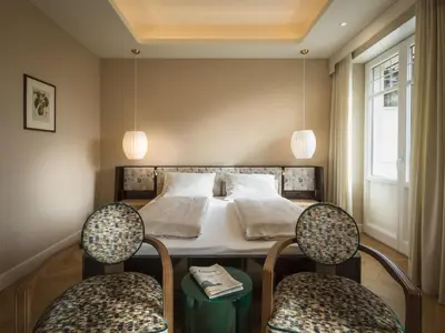 a bedroom with a bed with two chairs at Villa Bavaria in Merano