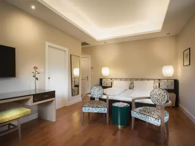 a hotel room with a bed and two chairs at Villa Bavaria in Merano