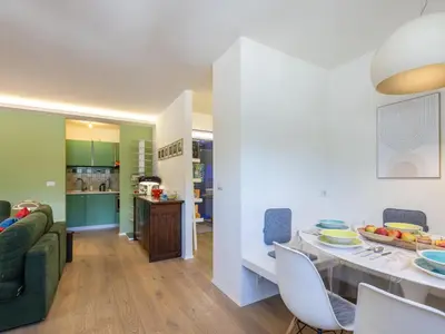 a kitchen and a living room with a table and chairs at Apartment Enrosadira-13 by Interhome in Alba di Canazei
