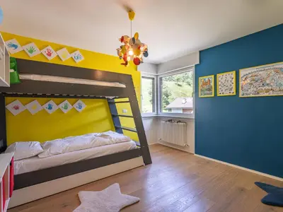 a bedroom with a bed and a green couch at Apartment Enrosadira-13 by Interhome in Alba di Canazei