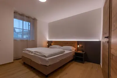 a bedroom with a large bed and a window at Alpinia in Moena