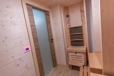 a tiny house with a closet and a desk at Alpinia in Moena