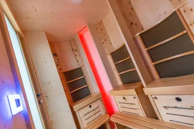 a tiny house with wooden shelves and a red beam at Alpinia in Moena