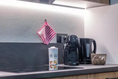 a kitchen counter with a coffee maker and an umbrella at Alpinia in Moena