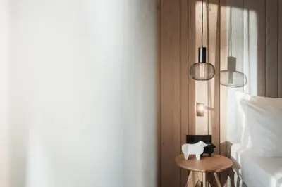 a bedroom with two pendant lights and a small table at Mountain Residence CLARA in Riscone