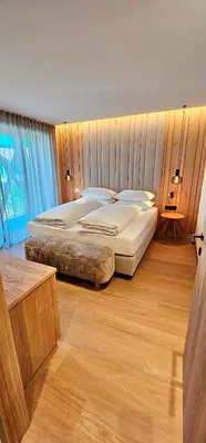 a bedroom with two beds and a large window at Mountain Residence CLARA in Riscone