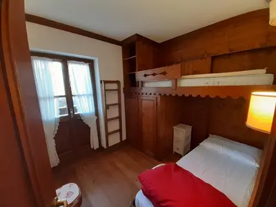 a bedroom with two bunk beds and a window at Casa elegante in San Vito di Cadore