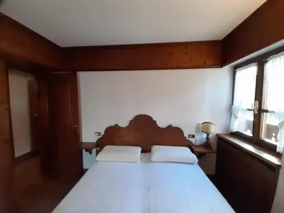 a bedroom with a wooden bed with two white pillows at Casa elegante in San Vito di Cadore