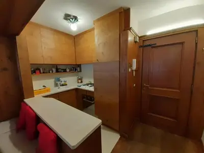a small kitchen with wooden cabinets and a door at Casa elegante in San Vito di Cadore
