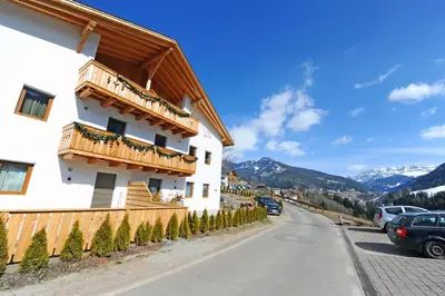 a building with a balcony on the side of a road at Mountain Apartment Hapeli in Ortisei