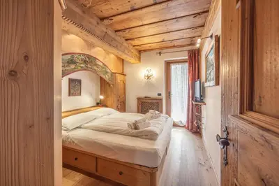 a bedroom with a large bed in a room with wooden walls at Casa Col, vicina alle piste da sci e con vista Dolomiti in Cortina dʼAmpezzo
