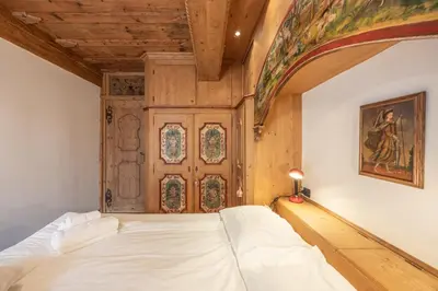 a bedroom with a bed and a wooden door at Casa Col, vicina alle piste da sci e con vista Dolomiti in Cortina dʼAmpezzo