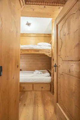 a bedroom with two bunk beds in a wooden cabin at Casa Col, vicina alle piste da sci e con vista Dolomiti in Cortina dʼAmpezzo