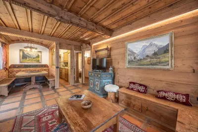 a living room with a couch and a table in a cabin at Casa Col, vicina alle piste da sci e con vista Dolomiti in Cortina dʼAmpezzo