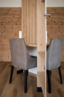 two gray chairs sitting next to a wooden cabinet at Mira Sabiona Guesthouse in Gufidaun