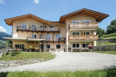 a large house with balconies and a gravel driveway at Mira Sabiona Guesthouse in Gufidaun