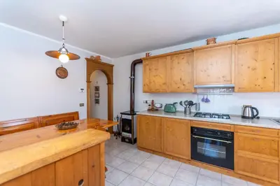 a kitchen with wooden cabinets and a stove at Casa Caracoi in Rocca Pietore